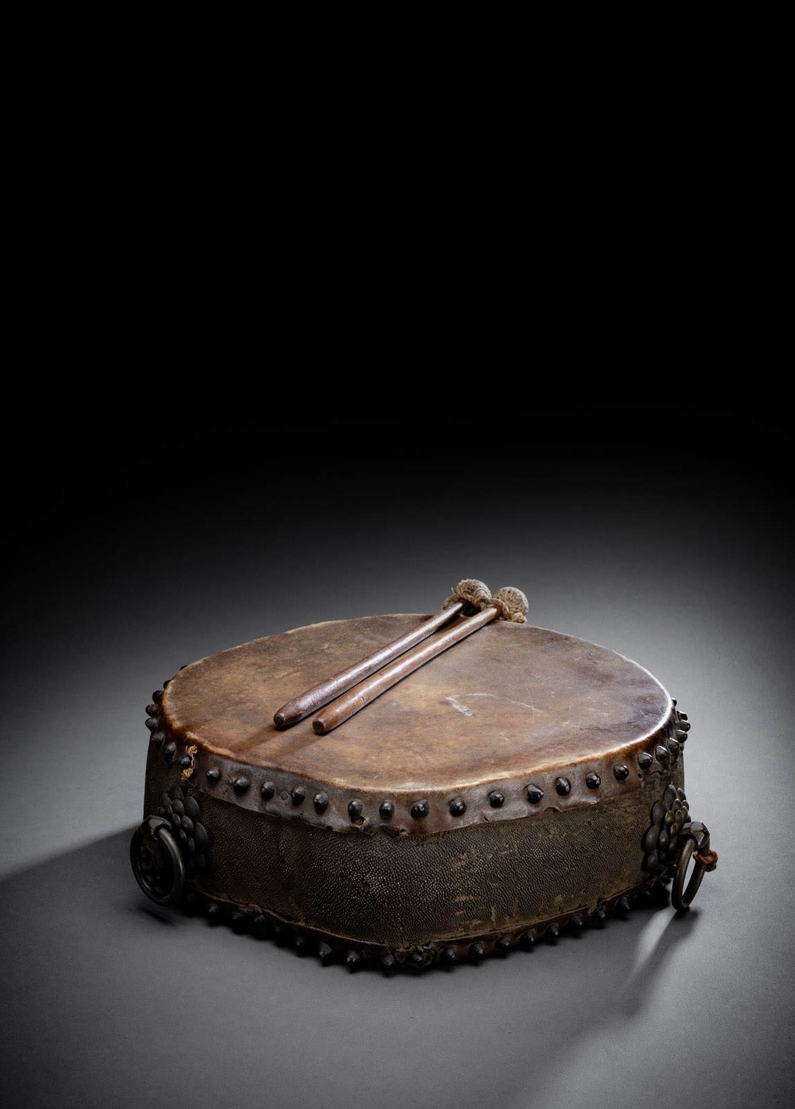 <b>A LEATHER DRUM WITH IRON RIVETS AND TWO STICKS</b>