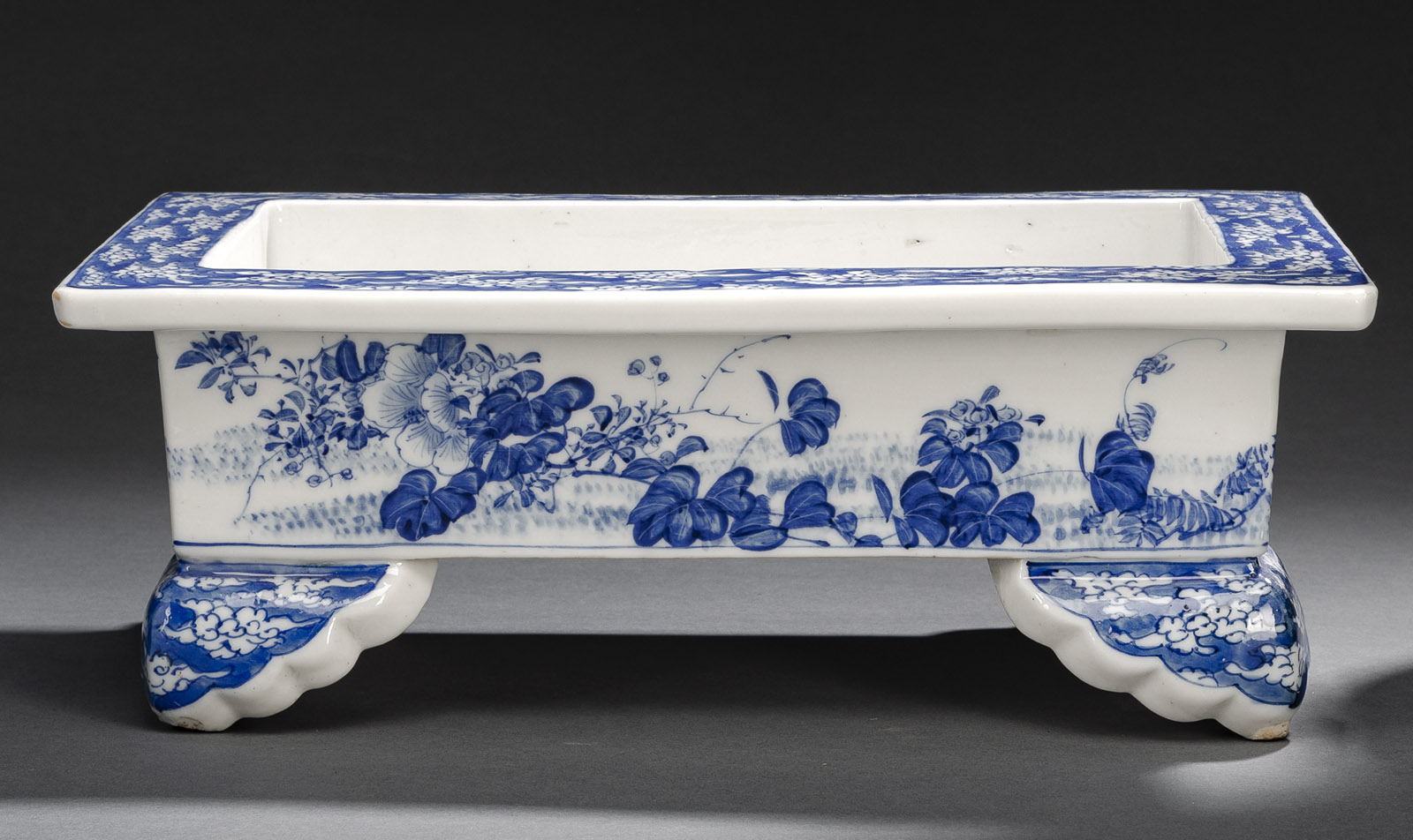 <b>Rechteckige, vierfüßige Pflanzschale aus Porzellan mit unterglasurblauem, floralen Dekor und Wolkenmotiven</b>