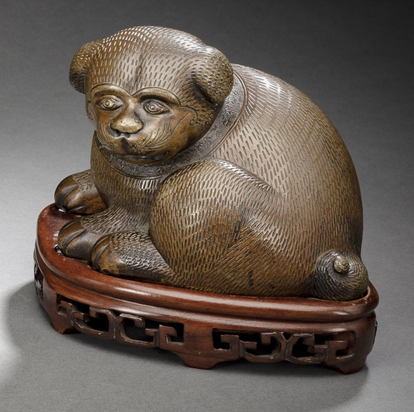 <b>A CAST BRONZE MODEL OF A SEATED PUPPY ON A CARVED WOOD STAND</b>