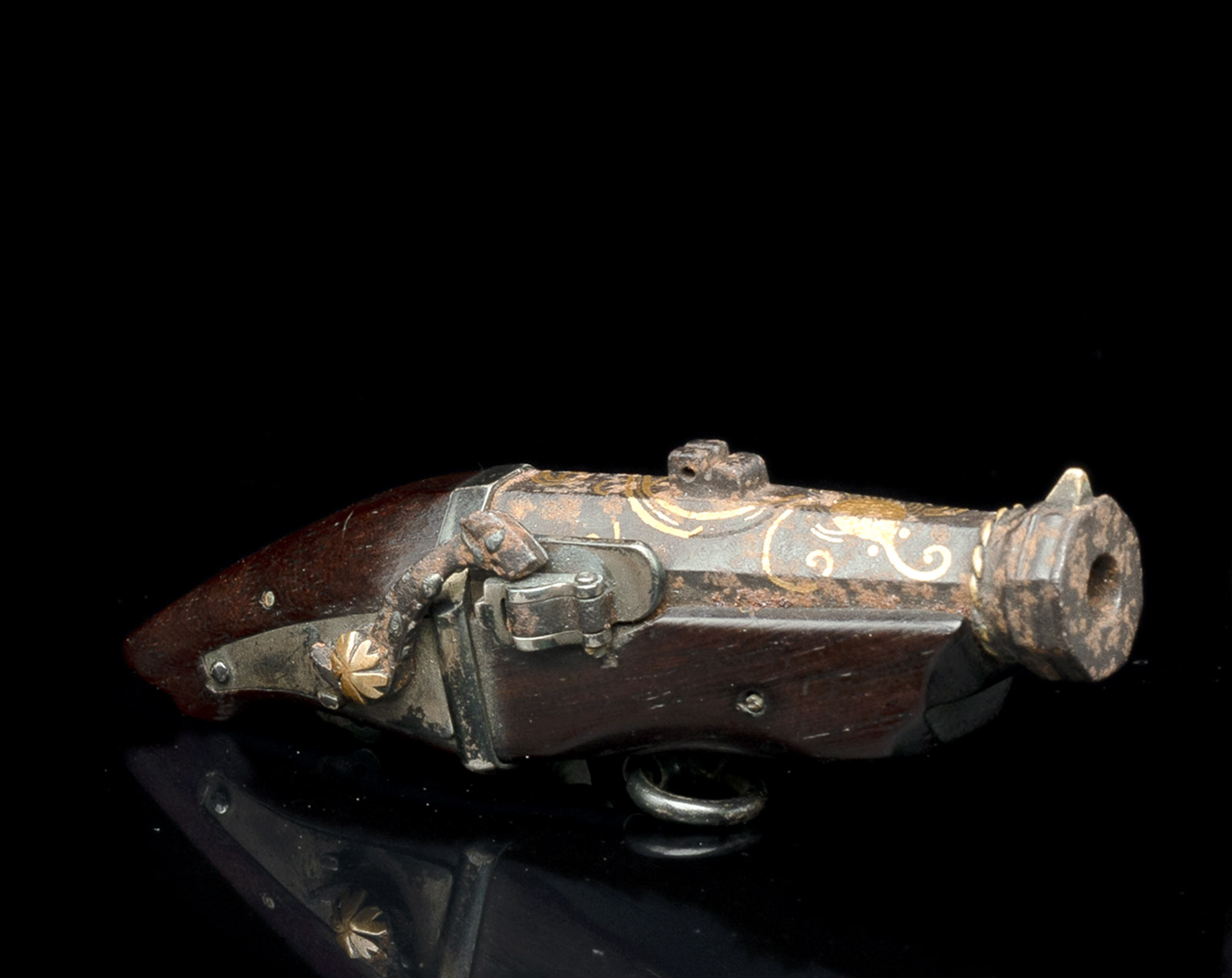 <b>Netsuke in Form einer Pistole aus Holz mit Details aus Eisen</b>