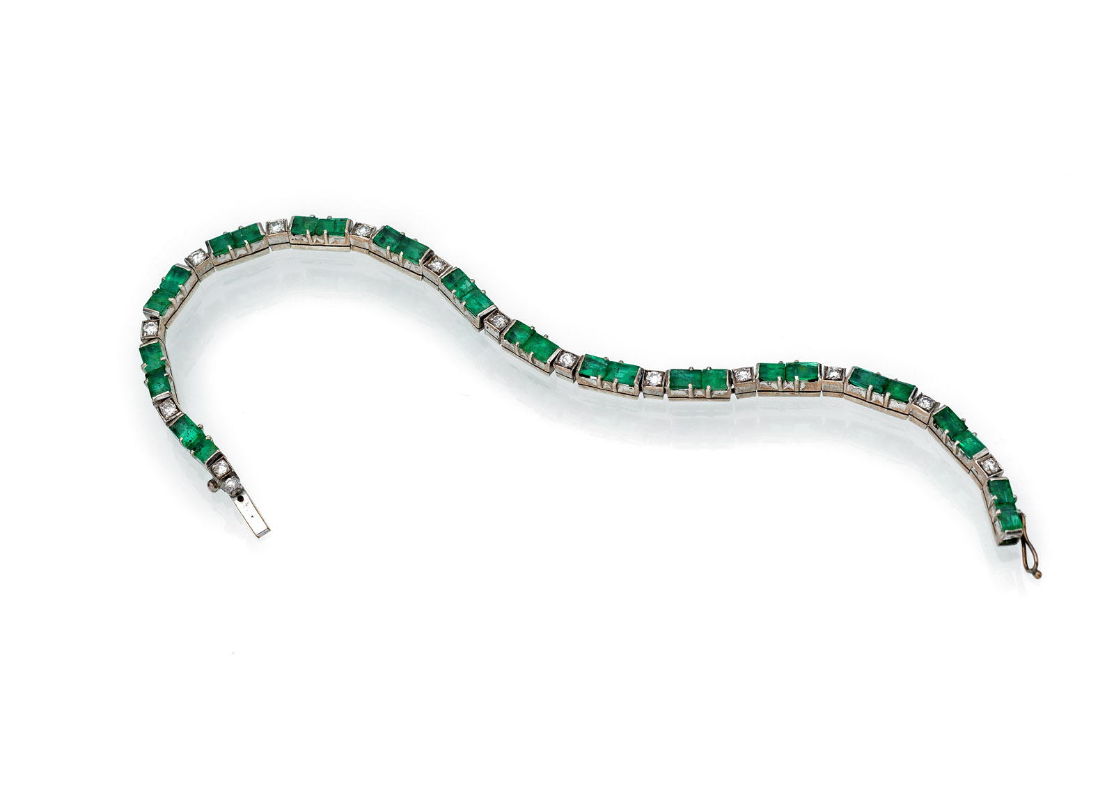 Silver, set with 28 baguette-cut emeralds (tog.ca. 4,2 ct.), and 14 diamonds (tog.ca. 0,7 ct.). Circa 11,4 g. 3-4 emeralds damaged