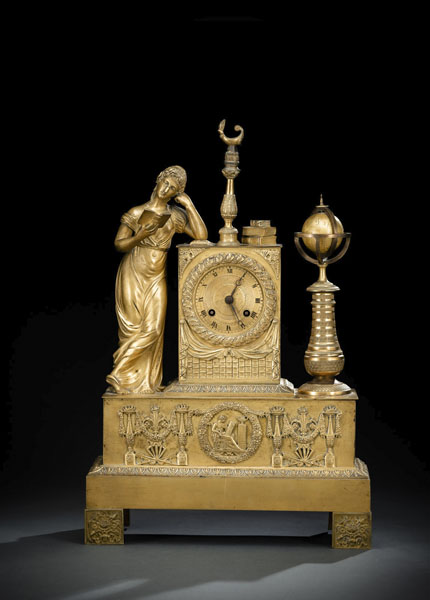 Bronze case with a three-dimensional representation of geography with globe and books and applied base relief. Remains of gilding. Dial with Roman numerals and steel hands. Parisian movement with 8 day going, half hour striking on bell and thread suspension. Pendulum missing, rest., running not checked.