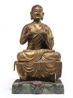 <b>A GILT-BRONZE FIGURE OF A LAMA ON A BRONZE PEDESTAL</b>