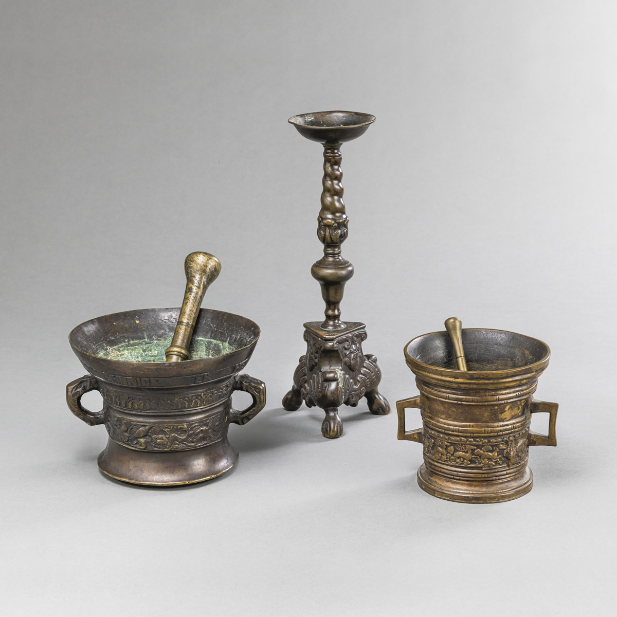 <b>TWO BRONZE MORTARS WITH PESTLES AND A CANDLESTICK</b>