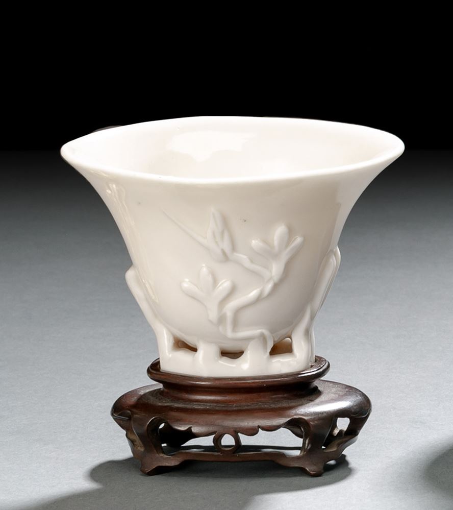 <b>A SMALL DEHUA PRUNUS LIBATION CUP ON CARVED WOOD STAND</b>
