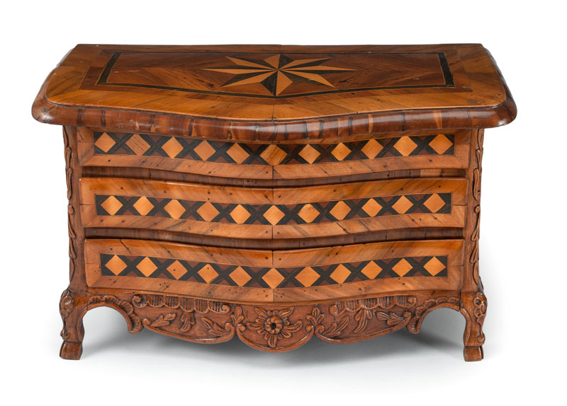 The moulded body on 4 feet with three drawers, floral relief carving and star marquetry. Additions, damages due to age.