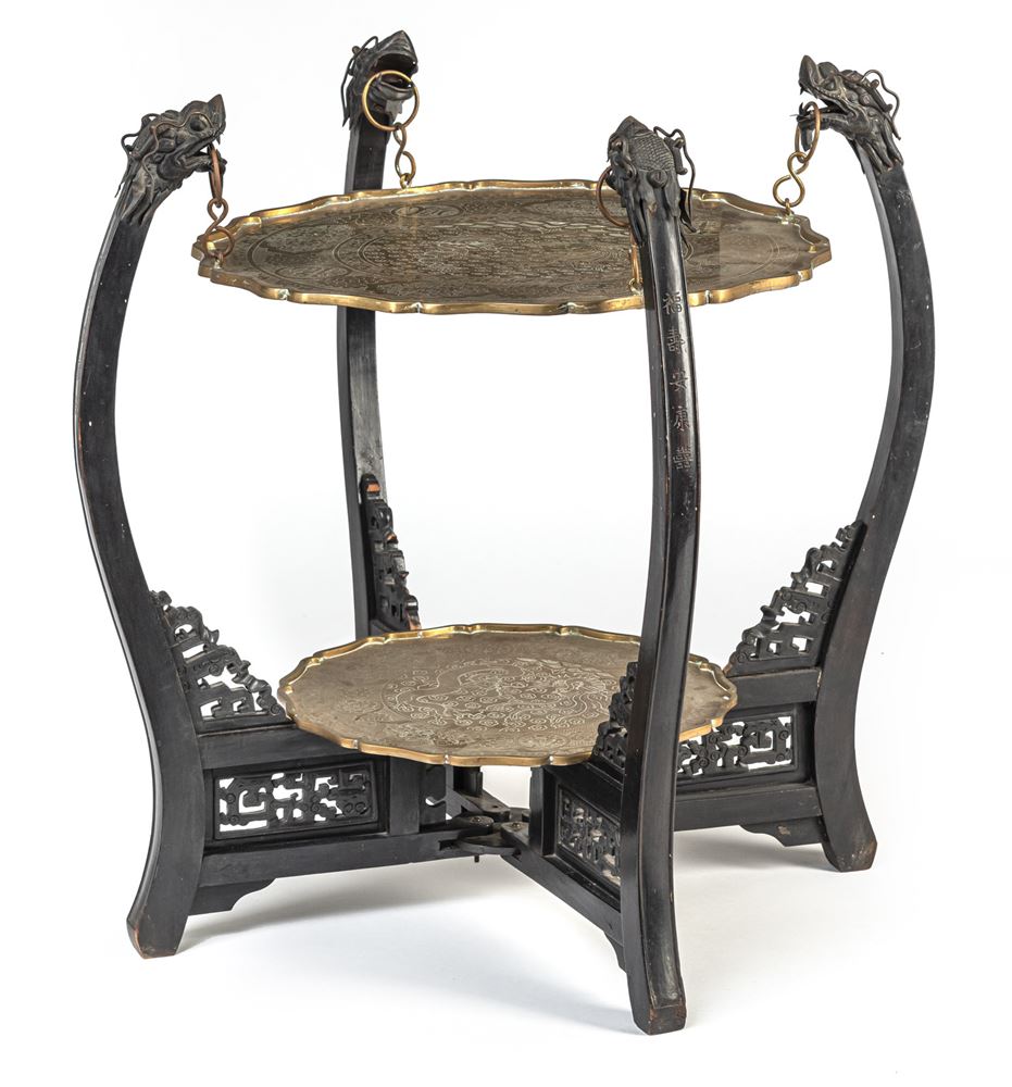 <b>A DARK WOOD SMOKING TABLE DECORATED WITH DRAGON HEADS AND TWO BRASS TRAYS ENGRAVED WITH A PAIR OF DRAGON AND PHOENIX BIRD AND CHINESE CHARACTERS</b>
