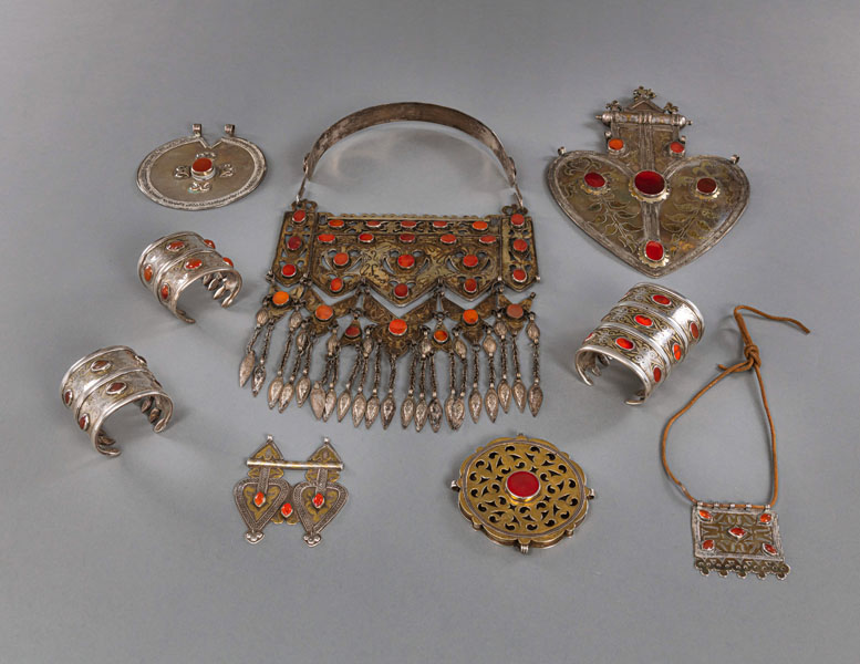 <b>A GROUP OF NINE PIECES OF JEWELRY, INCLUDING BRACELETS, CHEST AND BACK ORNAMENTS, PARTIALLY GILDED SILVER WITH CARNELIAN STONE EMBELLISHMENTS</b>