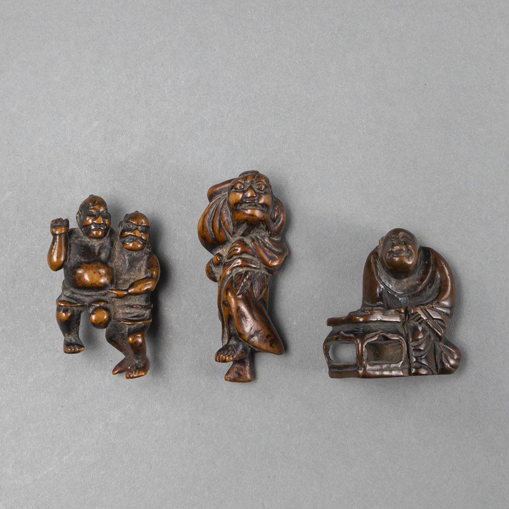 <b>A GROUP OF THREE CARVED WOODEN NETSUKE INCULDING  TWO SUMO WRESTLERS</b>