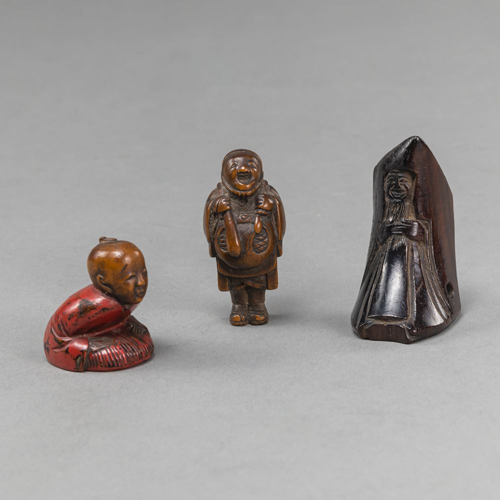 <b>A GROUP OF THREE CARVED WOODEN NETSUKE PARTLY PAINTED</b>