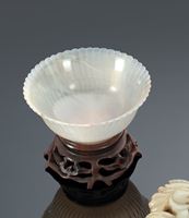 <b>A FINE CARVED CHRYSANTHEMUM MUGHAL-STYLE AGATE BOWL ON CARVED WOOD STAND</b>