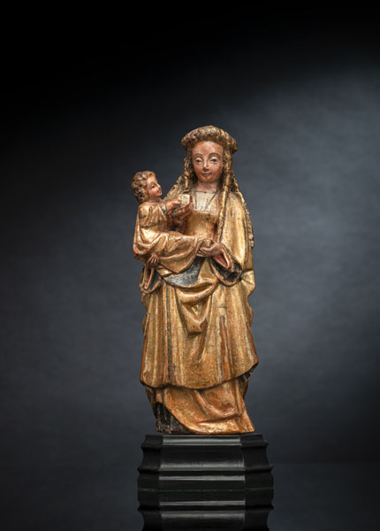 Nussbaum, rückseitig geflacht. Schöne Madonnenfigur mit Haube, das Kind mit Buch sitzt lesend auf Ihrem rechten Arm. Rückseitig die gestempelte Stadtmarke von Mechelen, die drei Balken (De drie Palen), vorderseitig auf dem Gewandrock gestempelt 