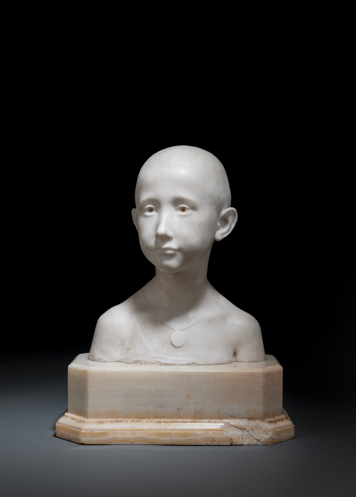 A white marble bust of a young boy. Signed and dated at the back 