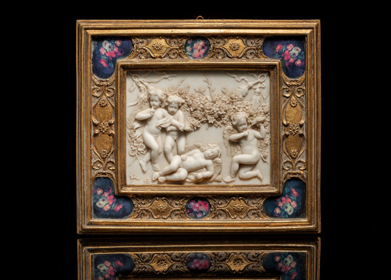 In a decorative frame with floral prints. Minor chipping, traces of age.