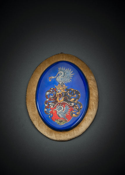 Oval copper plaque with translucient and opaque enamel. A coat of arms with a swan. Minor damage to bottom part. Fixed on a velvet lined frame.