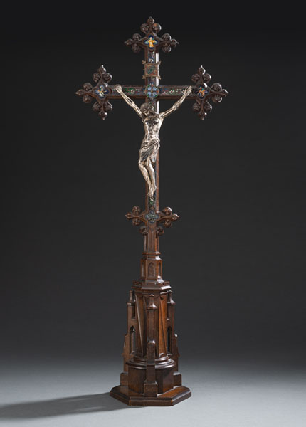 Gothic style carved wood cross with applied plaques and ribbons with cloisonné and painted enamel, two applied silver plaques above Body of Christ. The Body of Christ made of silver. Minor damages due to age.