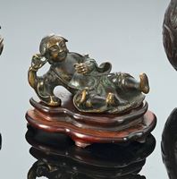 <b>A BRONZE WEIGHT IN SHAPE OF LIU HAI WITH A CASH BAND ON A CARVED WOOD STAND</b>
