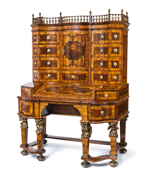 <b>Rich ribbon and fillet marquetry. The lower frame with six legs on pressed ball feet and with four full-round carved Atlant figures at knee height. Hinged writing desk with red leather liner in front of a cabinet with three drawers, flanked by four side drawers. The curved upper part with a central tabernacle compartment in front of a cabinet with 9 drawers, framed by further nine drawers with central locking. The gallery with vase motifs was added later. Bronze fittings with lion motifs. Rest., minor additions and traces of age.</b>