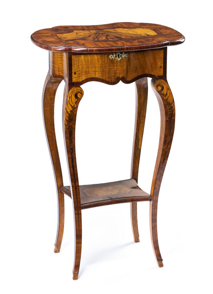The moulded hinged top on a frame with small compartment and side drawer on curved legs with tray shaped stretcher. Minor restoration and traces of age.
