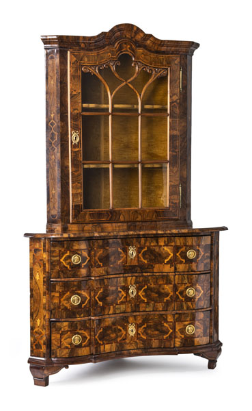 The lower commode part with three drawers, the drawers with old paper liners. The upper part with one door with glazed panels. Floral and strapwork marquetry. Restorations, minor additions and traces of age.