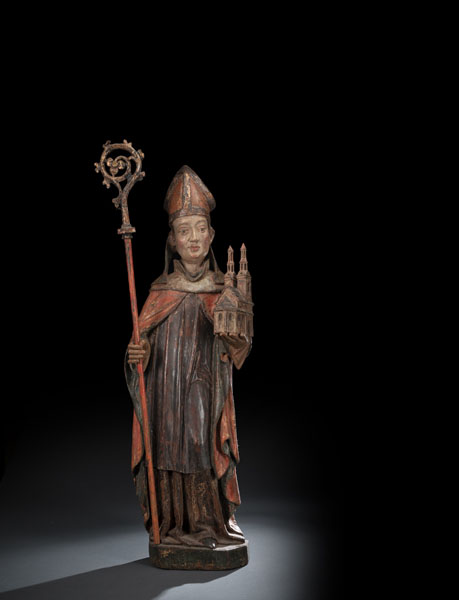 Standing figure of the Saint with miter, crosier and a model of the St. Wolfgang church. Limewood, carved with deeply hollowed back, later polychromy. A very few remnants of old polychromy. Rest. Damages due to age. Crosier probably later.