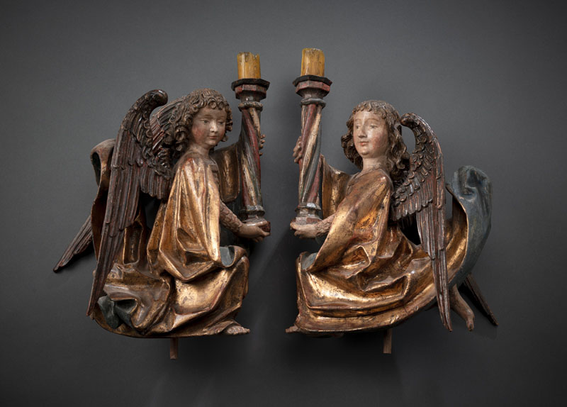 Hardwood, probably limewood, carved in full round. Kneeling, winged angels with candlesticks, scales dress and coat. Old polychromy and gilding as well as incarnate overpainted. Rest., additions.