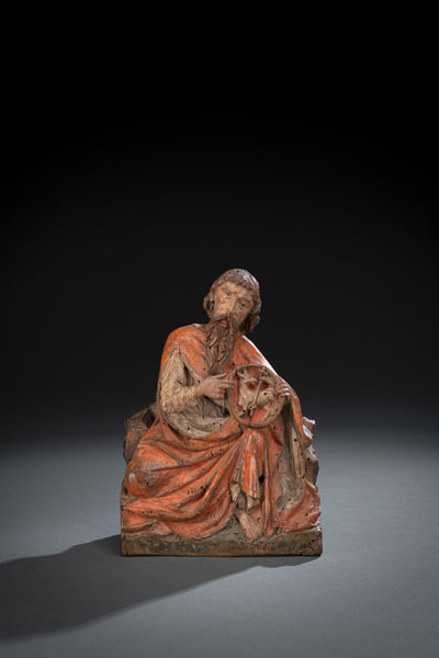 Sitting figure of the Saint holding a plate with Agnus Dei in his hands. Hardwood, probably fruitwood, carved in full round. Probably later painted. Damages due to age, rest.