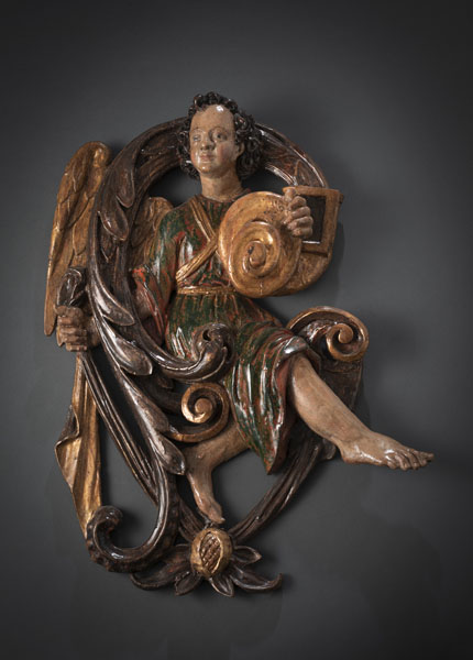 <b>Limewood relief carving. Winged angel with volute, cornucopia, pomegrate and foliage pattern. Remnants of old polychromy and gilding with varnish coating. Restorations and damages due to age.</b>