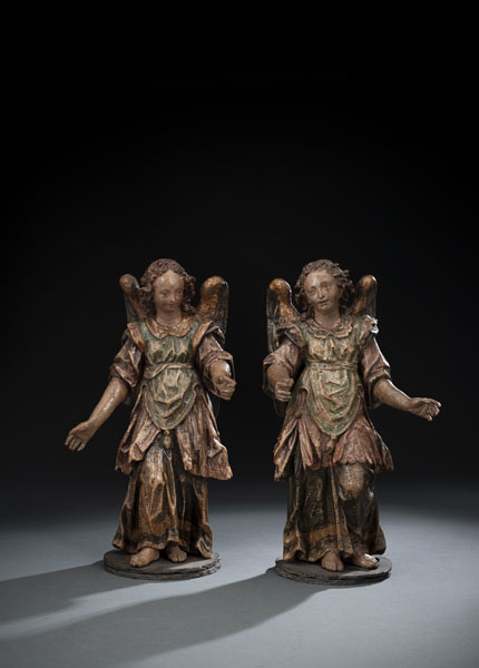 A pair of angels in coats with rich drapery. Hardwood, carved with flattened back. Additions. The polychromy worn, with overpaintings and varnish. Restorations and damages due to age. Later slate stands.