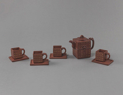 <b>A NINE-PIECE ZISHA TEA SET WITH GOLD CALLIGRAPHY DECORATION AND MATCHING WOODEN BOX</b>