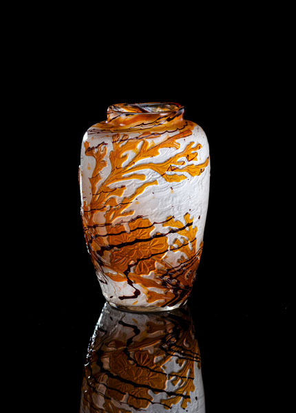Farbloses Glas mit bernsteinfarbenem Überfang und manganfarbener Sprenkelung. Geätzter Dekor von Algen und Wasserpflanzen. Hochgeätzt signiert 