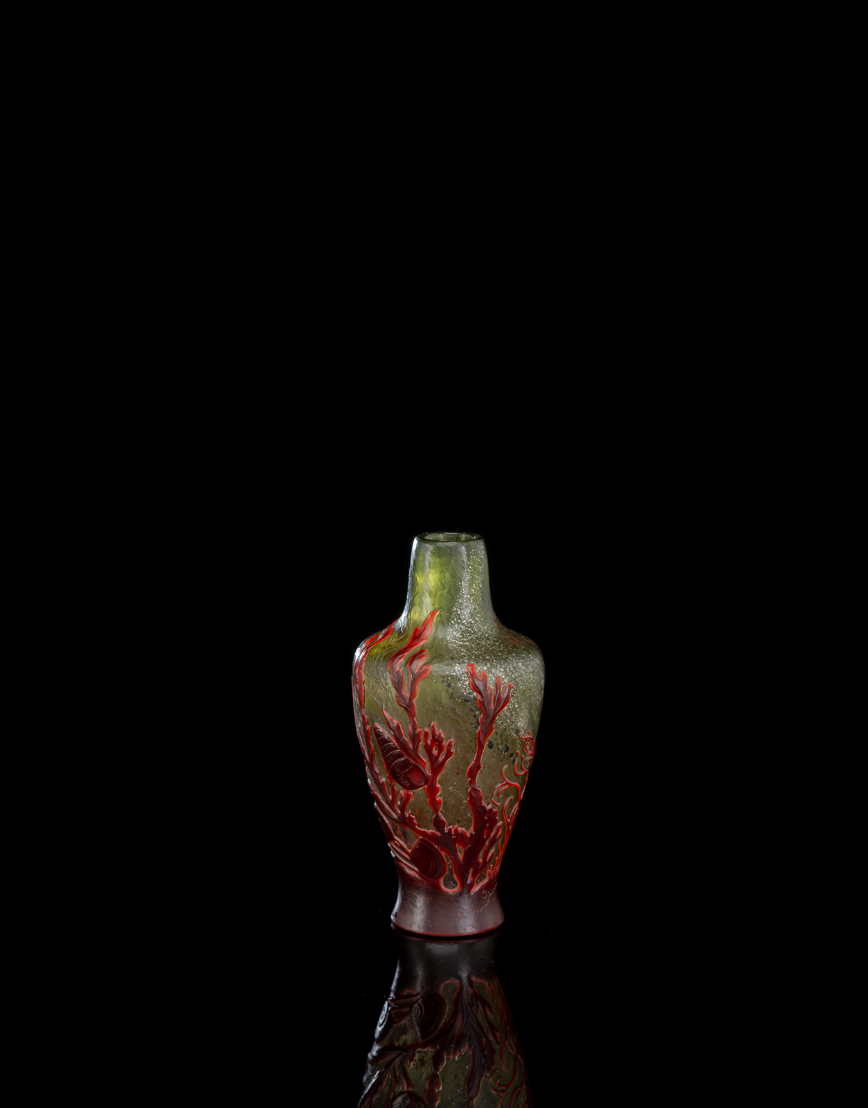 Grünes Glas mit silbernen und roten Pulvereinschmelzungen und Gravur von Wasserpflanzen, roter Glasüberfang mit geätztem Dekor von Seegras und Muscheln. Ätzsignatur 