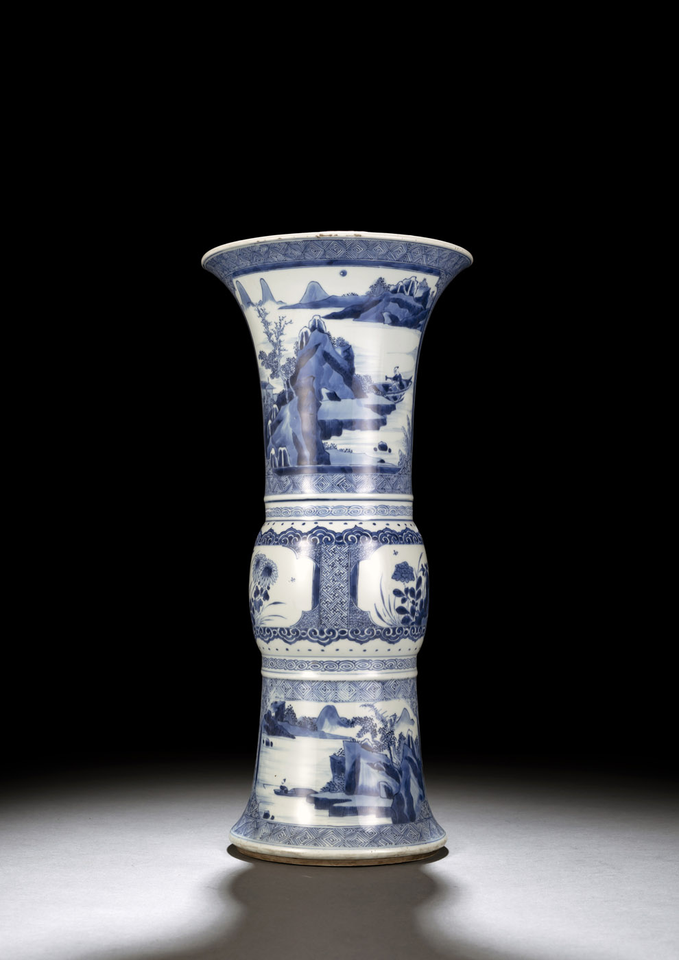 <b>A GU-SHAPED BLUE AND WHITE VASE WITH SCENES OF SEA LANDCAPES AND FLOWER MEDAILLONS</b>