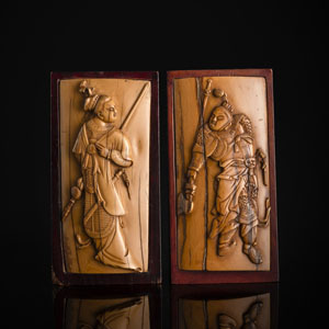 <b>Paar Buchstützen aus Holz mit Tafeln aus Elfenbein, geschnitzt in hohem Relief mit der Generale Mu Guiying mit Speer bzw. dem General Yang Yande mit Axt in Rüstung</b>