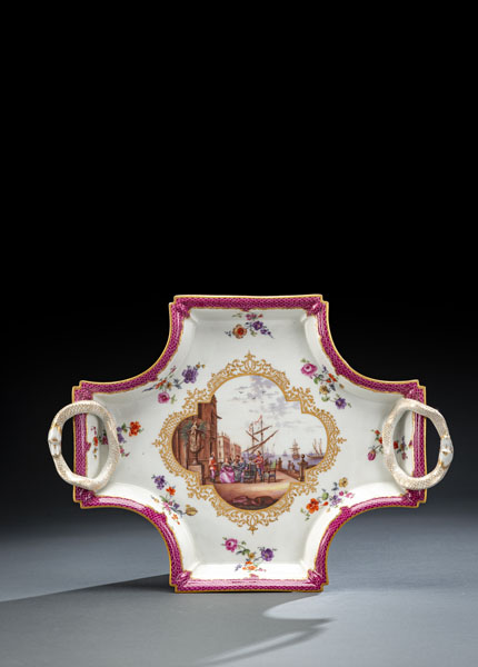 <b>Four-sided tray with snake handles and fish scale design in purple red, a gold framed centre medaillon with Kauffahrtei scene surrounded by lush bouquets of flowers. Blue crossed sword marks with star. (1st choice). Minute chip to rim.</b>