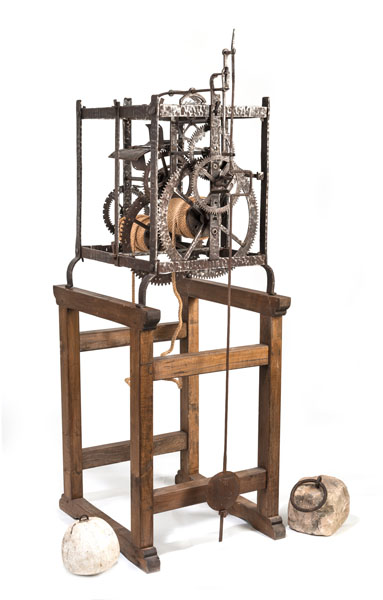 <b>Forged and dowelled iron movement with hour striking, geared lock plate and anchor escapement. With pendulum and stone weights, restored, additions. On a wooden stand.</b>