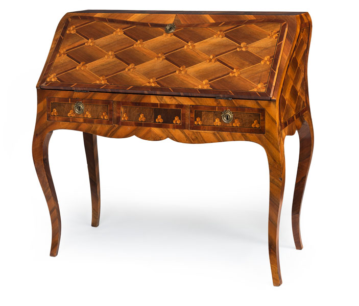 <b>Banded and crossbanded overal and inlaid with cube parquetry the hinged rectangular slope above a fitted interior with four drawers and open compartments, above two small frieze drawers, on cabriole shaped tapering legs. Some damages due to age.</b>