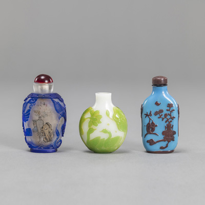 <b>A GROUP OF THREE CARVED GLASS SNUFF BOTTLES WITH COLOURED OVERLAY SHOWING BIRDS/ ANTIQUITIES</b>