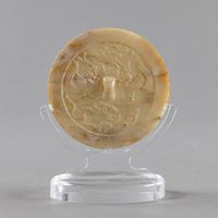 <b>A CARVED YELLOW-WHITE JADE MIRROR WITH PHOENIXES AND ANIMALS</b>