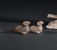 <b>A PAIR OF PAINTED EARTHENWARE RECUMBENT RAMS</b>