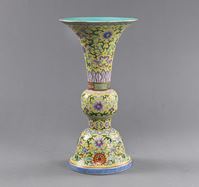 <b>A YELLOW-GROUND PORCELAIN VASE IN THE ARCHAIC FORM OF A GU, DECORATED WITH EIGHT BUDDHIST TREASURES BETWEEN LOTUS TENDRILS</b>