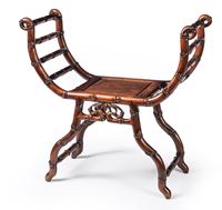 <b>A CROSS-SHAPED WOOD STOOL WITH ARMRESTS AND BAMBOO DECORATION</b>