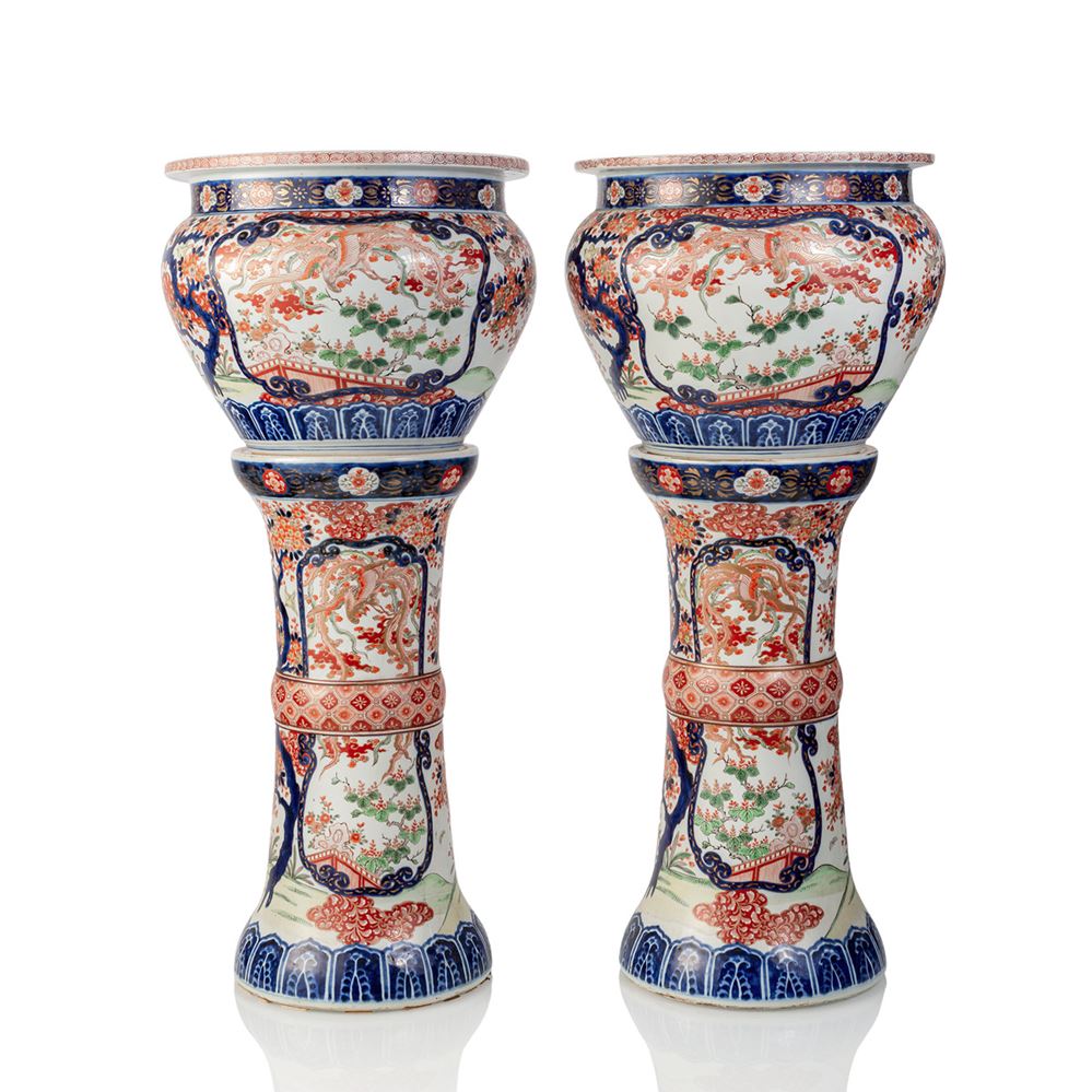 <b>A pair of porcelain cachepots with matching stands with floral decoration in the colours of the Imari palette</b>