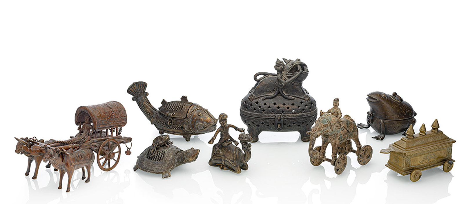 <b>A GROUP OF EIGHT BRONZE, COPPER AND BRASS OBJECTS, AMONG OTHER HINGED BOXES AND CARRIAGES IN ANIMAL SHAPE</b>
