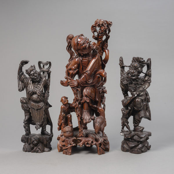 <b>Drei Holzschnitzereien daoistischer Figuren, u.a. Li Tieguai und Zhong Kui, teils Metalldraht eingelegt</b>