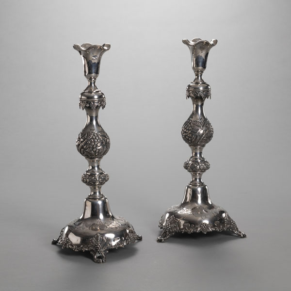 <b>A PAIR OF FLORAL TOOLED SILVER CANDLESTICKS</b>