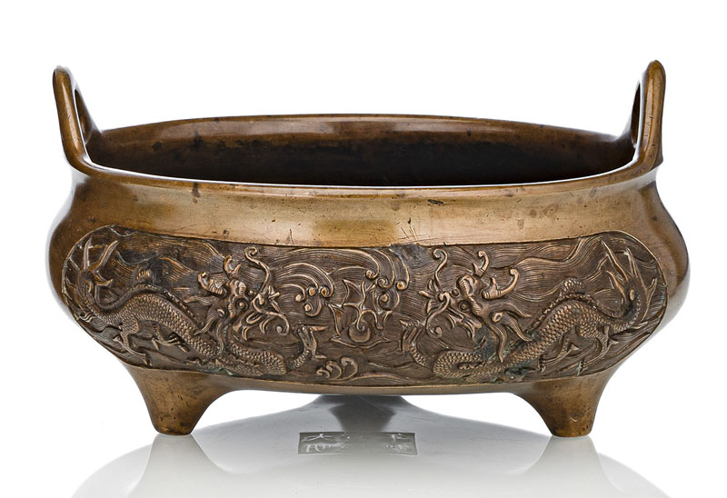 <b>A WELL-CAST BRONZE TRIPOD CENSER WITH DRAGONS AMIDST WAVES</b>