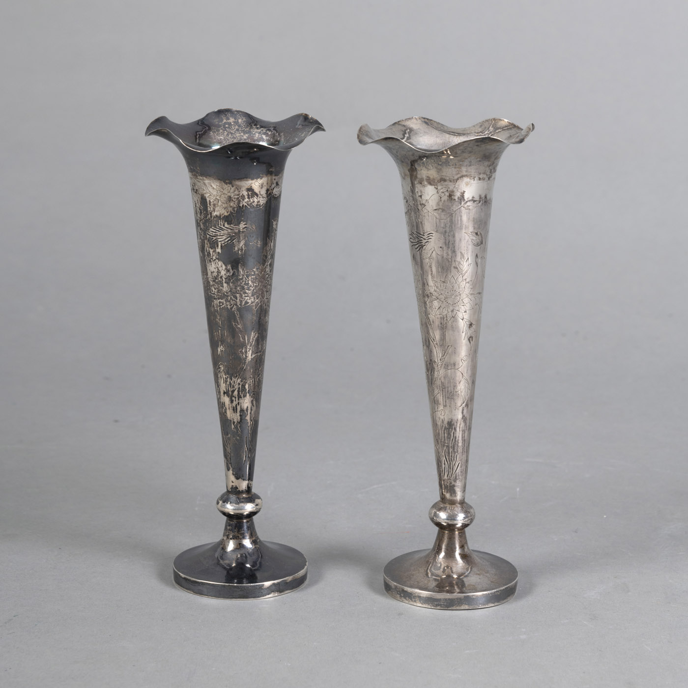<b>A PAIR OF SLENDER SILVER VASES ENGRAVED WITH FLORAL AND BIRD DECORATION</b>