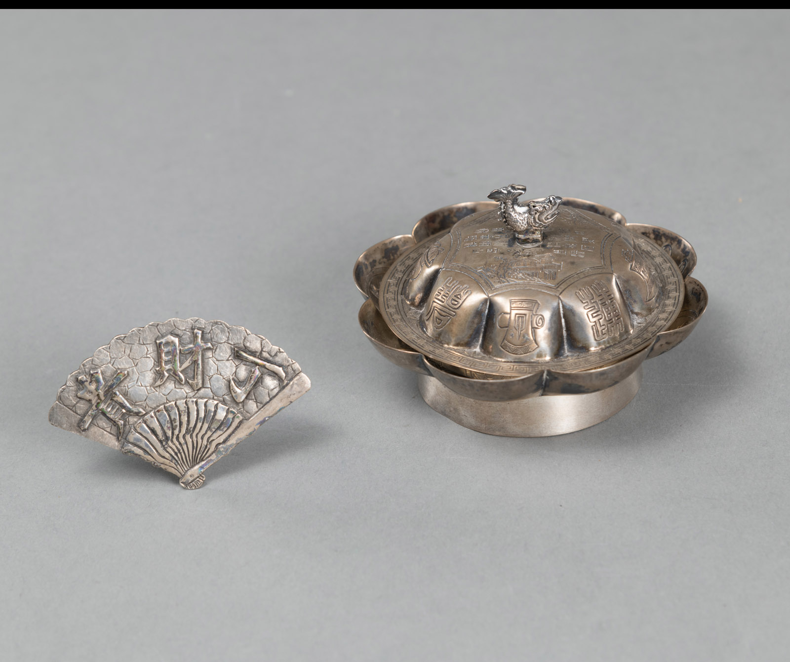<b>Deckel und Untersetzer für einen Teebecher und ein fächerförmiger Aufsteller aus Silber mit glückverheißender Inschrift 'Ding Cai Gui'</b>