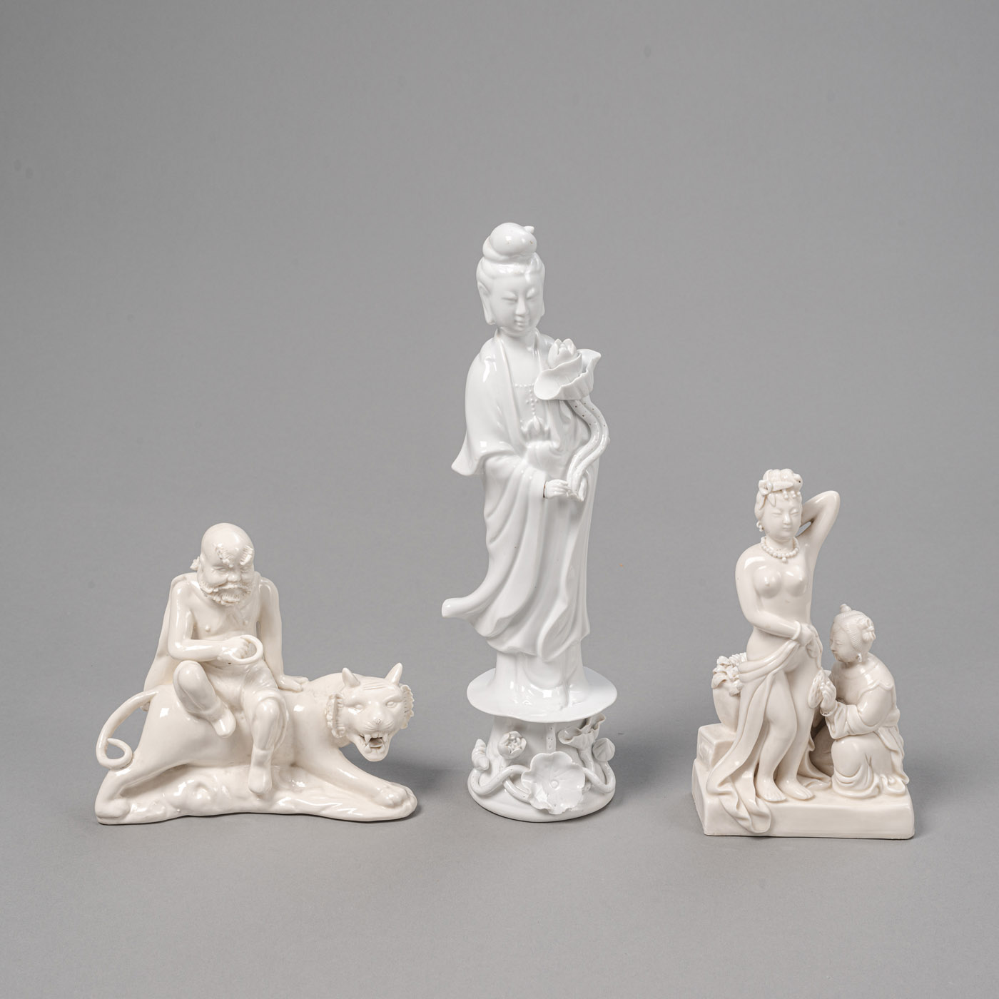 <b>Drei 'Blanc-de-Chine'-Figuren, u. a. ein Luohan auf einem Tiger, Guanyin</b>
